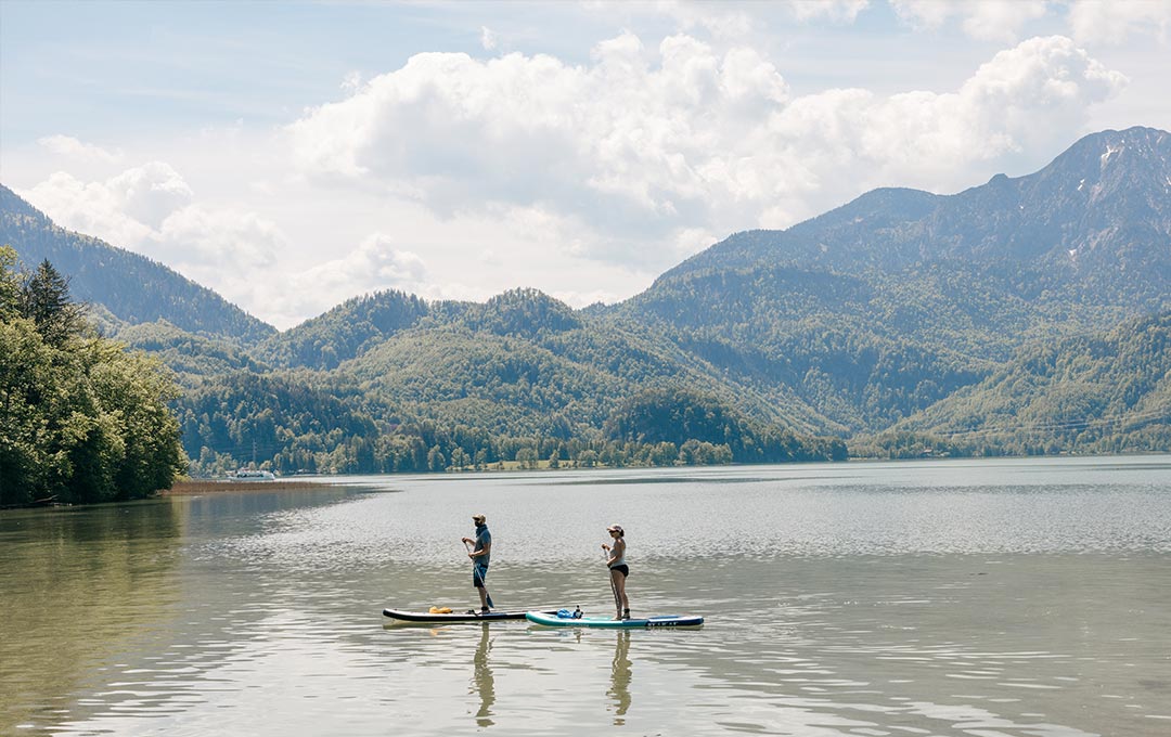 Zwei Aktivurlauber mit ihren SUP-Boards auf einem der beiden Seen im Zwei-Seen-Land